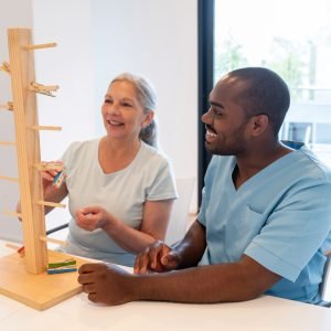 cheerful senior woman in occupational therapy with a black male patient having fun